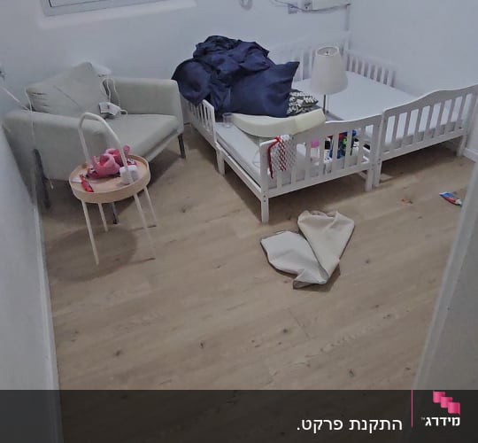 רצפת פרקט בחדר ילדים עם מיטה וכורסה